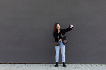 Fototapeta na wymiar Young woman taking selfie on the street