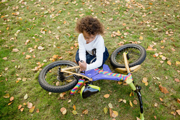 Girl screws parts onto bicycle