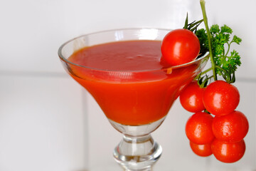 juicy bunch of red small cocktail tomatoes, tomato juice is poured into a glass, healthy food concept, healthy drink, ingredient for making salad, sauce