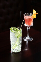 Different cocktails at bar in nightclub party. Cocktails on black background in glass glasses.