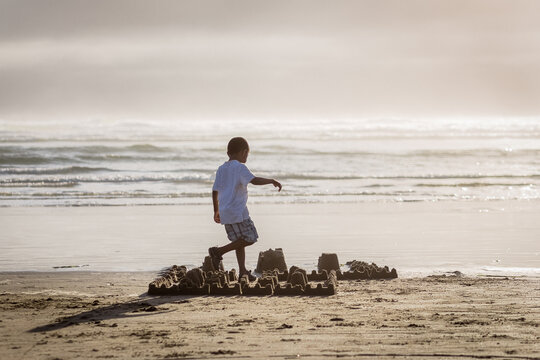 Boy with sandcastle on beach