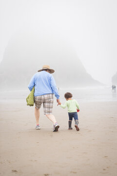 Grandmother stomps on beach with granddaughter