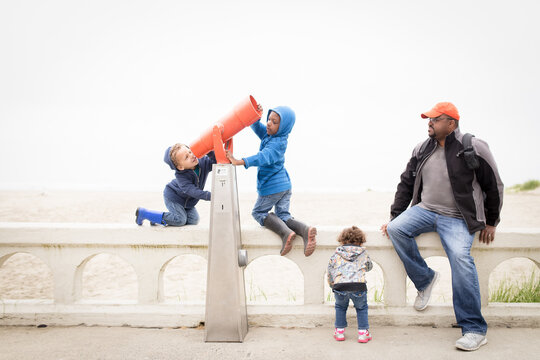 Family on vacation looks through telescope 