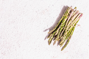 Ripe asparagus on a white textured plaster background