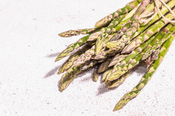 Ripe asparagus on a white textured plaster background