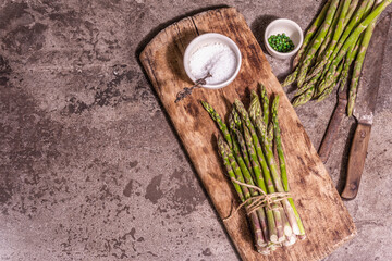 Fototapeta na wymiar Bunch of fresh green asparagus on vintage wooden chopping board