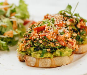 Avocado tofu toast and salad on white background