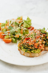 Avocado tofu toast and salad on white background
