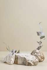 Abstract scene with composition of stones and eucalyptus leaves. Neutral beige podium background...