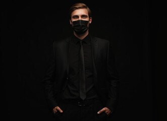Obraz premium Business Concept - Portrait Handsome Businessman in protective face mask on black background