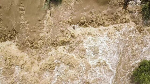 Aerial view of dirty river with muddy water in flooding period during heavy rains in spring.