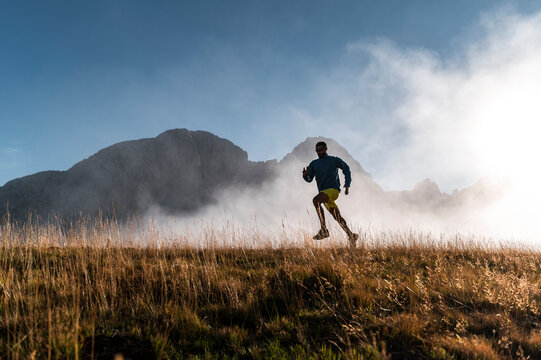 Silhouette of sportsman running against fog