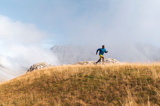 Adult sportsman doing workout against fog