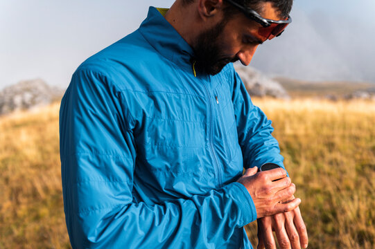 Middle aged trail runner checking smartwatch