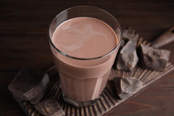 Fresh yummy chocolate milk on wooden table, closeup