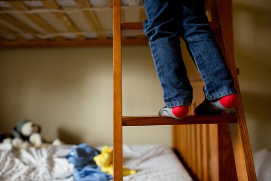 Child's feet climbing bunkbed ladder