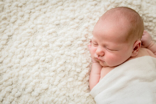 Baby asleep on textured blanket