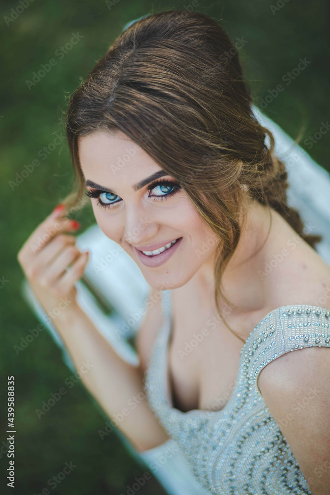 Canvas Prints Pretty Caucasian woman with a silver evening dress and heavy makeup sitting on a wooden bench