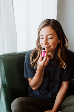 Brunette Woman Taking a Deep Breath of Essential Oil to Feel Calm