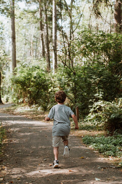 Young Boy Running down Wooded Path