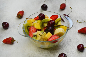 fresh summer fruit salad banana, kiwi, mango, strawberry and cherry, diet and healthy food
