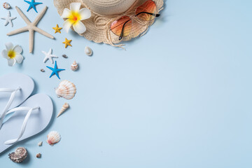 Obraz premium Summer beach background design concept with shells, hat, slipper on blue background.