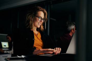 Successful young smiling portrait of a businesswoman typing on laptop in modern office