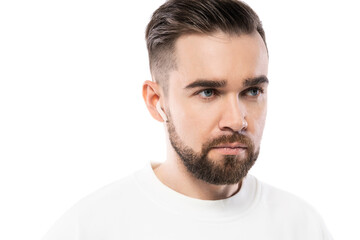 Handsome bearded man in white clothes  using wireless earbuds on white background