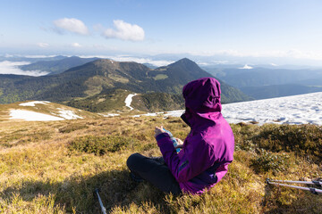 Woman hiker enjoying high peak view on mountains in summer. Pip Ivan peak. Marmarosy ridge, Carpathian, Ukraine