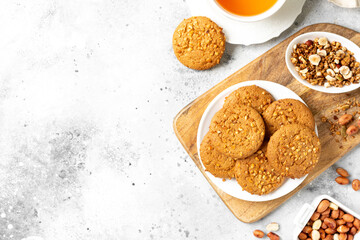 Healthy homemade oatmeal cookies with peanuts in a white plate on a light gray kitchen table view of sergu with copyspace