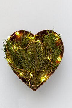 Heart shaped coniferous branches flat lay with festive twincle lights