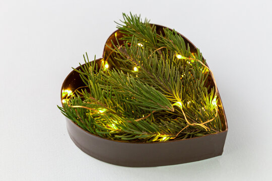 Heart shaped coniferous branches flat lay with festive twincle lights