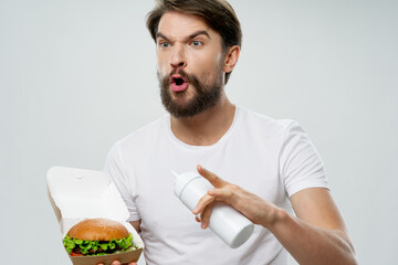 man with hamburger gesturing with his hands and surprised look open mouth model