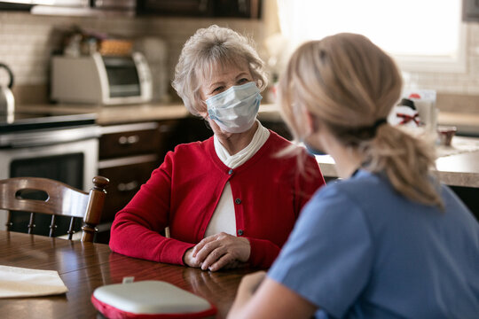 Health: In Home Care Nurse Talks With Senior Woman