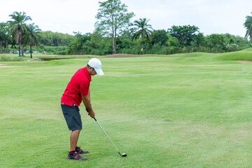 Male athlete hitting a golf ball into a hole