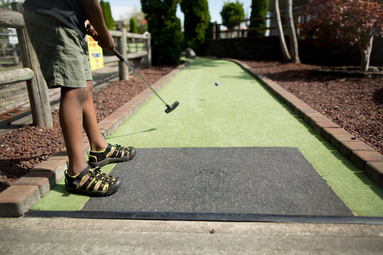 Boy tee's off at mini golf
