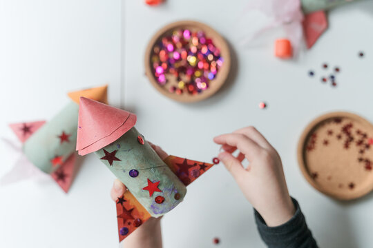 child decorates handmade paper rocket ship 