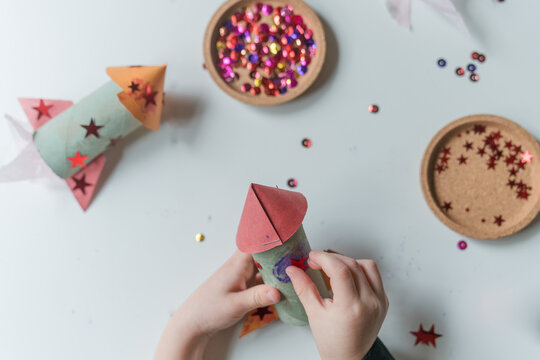 child makes paper rocket ship 