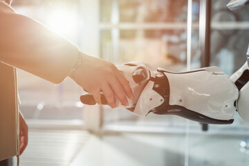 cropped view of businessman and robot shaking hands