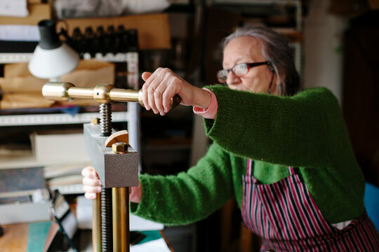 Woman adjusting a press in her workshop