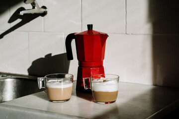 Coffe pot and cappuccino coffe cups on top of counter