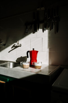 Coffe pot and cappuccino coffe cups on top of counter