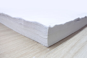 Many layers of white knitted fabric for sewing and production of T-shirts, panties, homewear, masks and bed linen. Photo from a light industry factory