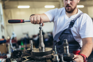 Technician working on checking and service car in workshop garage; technician repair and maintenance engine of automobile in car service