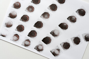 abstract background composition with reddish-black (brown) ink pad stamped loosely arranged on light background - photographed from above in a flat lay style