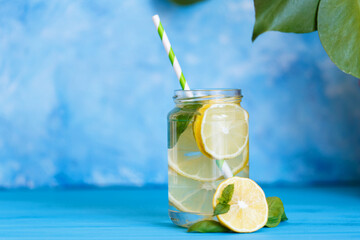 Tasty cool beverage with lemon and basil in mason jar glass