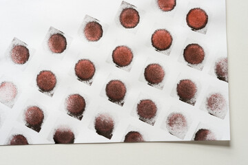 abstract background composition with reddish-black (brown) ink pad stamped loosely arranged on light background - photographed from above in a flat lay style