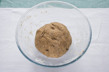 The glass bowl with freshly made bread dough. Homemade bread. Step by step recipe.