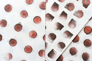 abstract background composition with reddish-black (brown) ink pad stamped loosely arranged on light background - photographed from above in a flat lay style