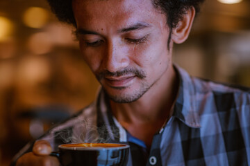 Asian man wear T-shirt drinking and play tablet at cafe shop on relaxing time.